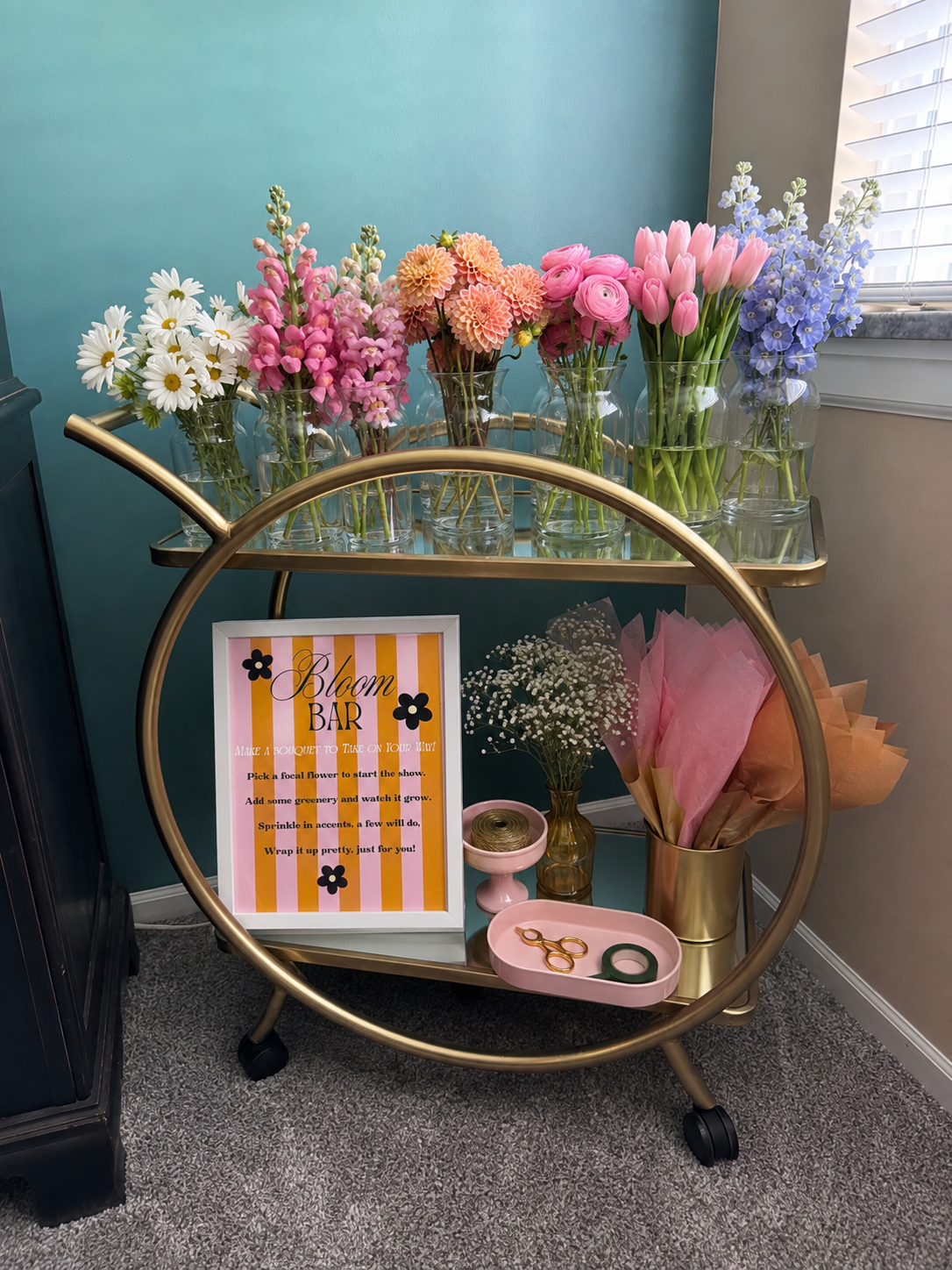 Gold circular flower cart with fresh pastel blooms and bouquet wrapping supplies